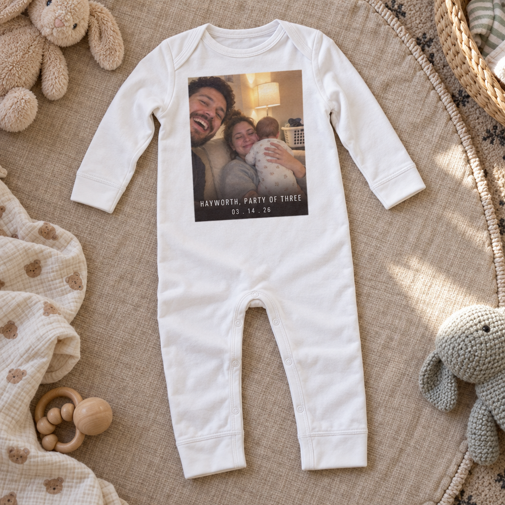 A custom long-legged baby bodysuit laid flat with a first name printed across the front