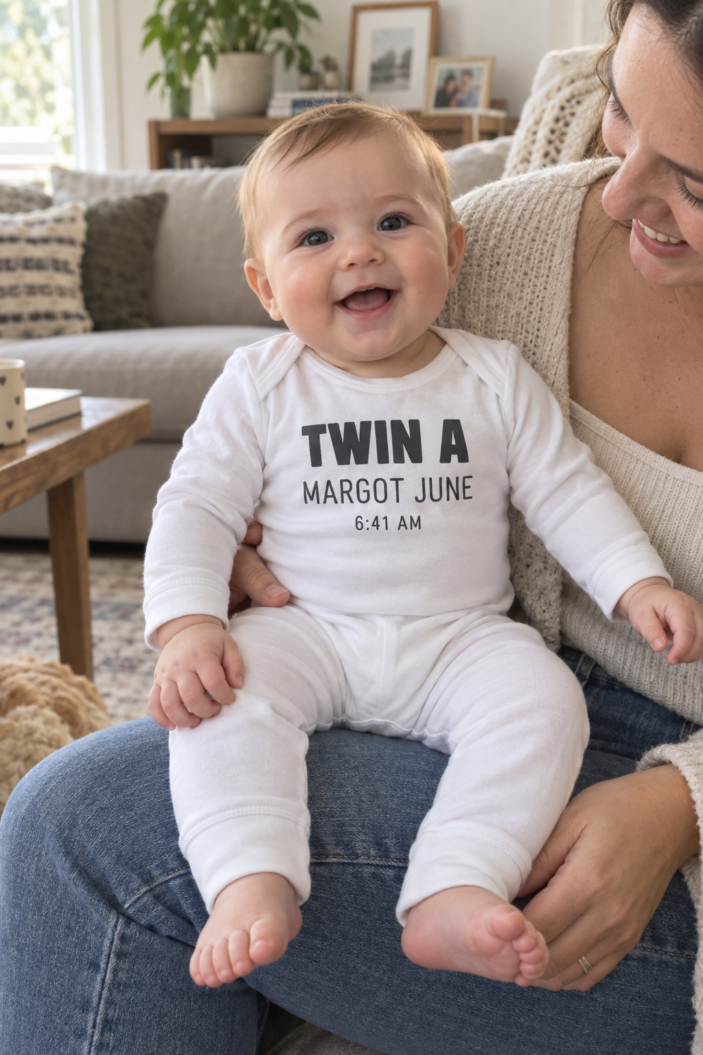 A long-legged baby one-piece laid flat showing the full length and the printed front design