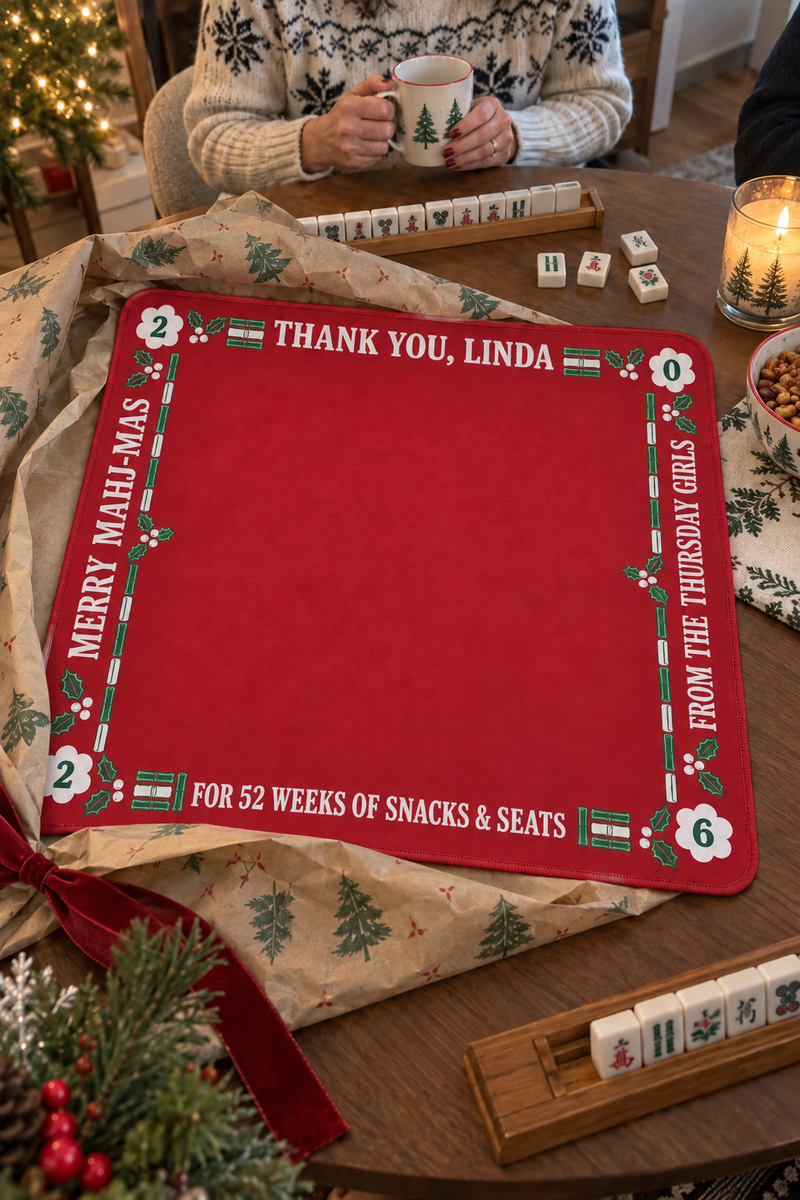 Red personalized mahjong mat reading Thank You, Linda, half unwrapped from holiday paper on a game table