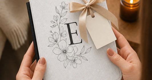Personalized Kindle case gift with original floral artwork, a monogram, ribbon, and blank gift tag.