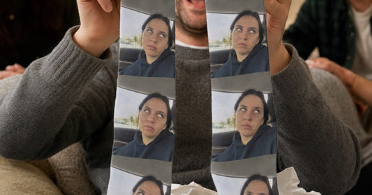 Recipient holding personalized photo socks printed with a familiar face.