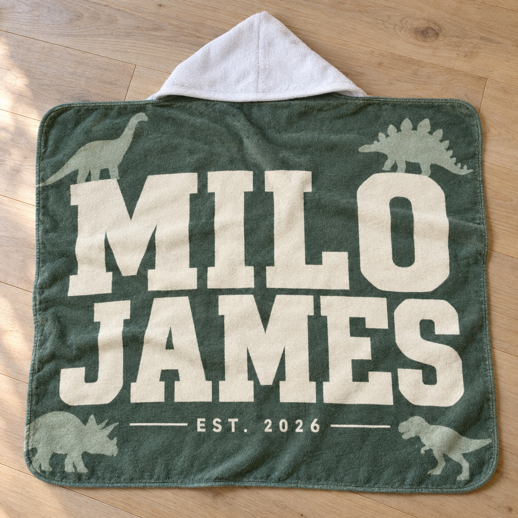 Custom Hooded Towel personalized with a photo and name, laid out in a warm nursery scene (01-hero.png)