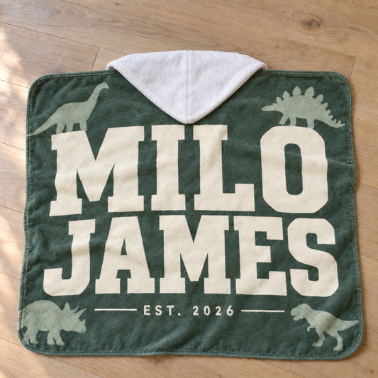 Custom Hooded Towel printed with a personalized design, laid out in a warm nursery scene