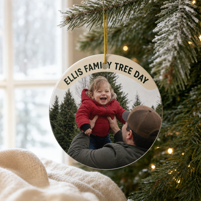 Personalized ceramic photo ornament with a family photo hanging on a lit Christmas tree