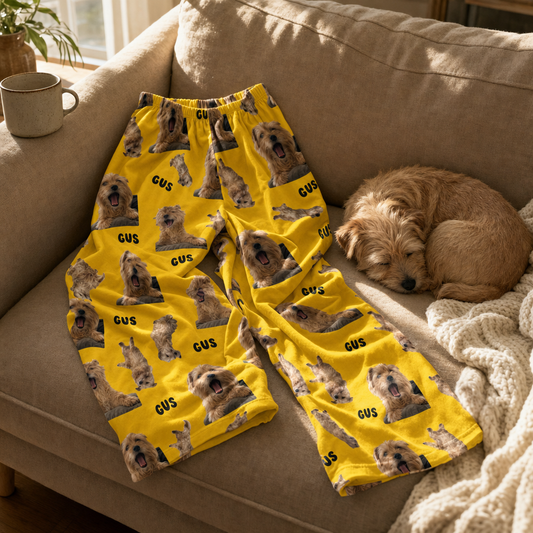 Custom pajama pants with a terrier photo design tossed naturally on a couch beside the family dog