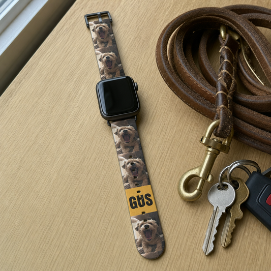 Custom Apple Watch band printed with a repeating dog photo and the name Gus, attached to an Apple Watch on a wooden table