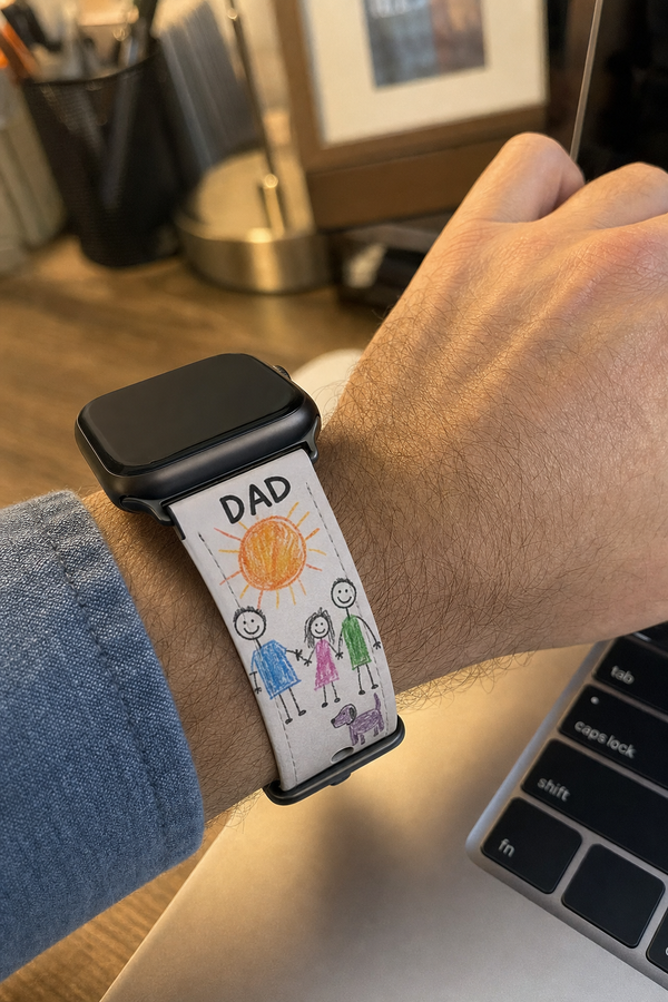 Custom Apple Watch band printed with a child's crayon drawing, worn at an office desk