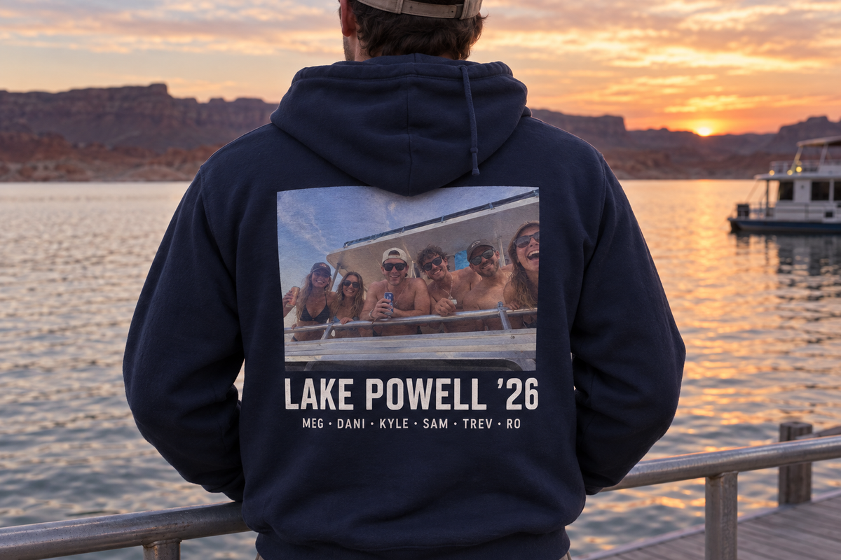 The back of a navy custom zip-up hoodie printed with a lake trip photo, a trip headline, and a row of first names