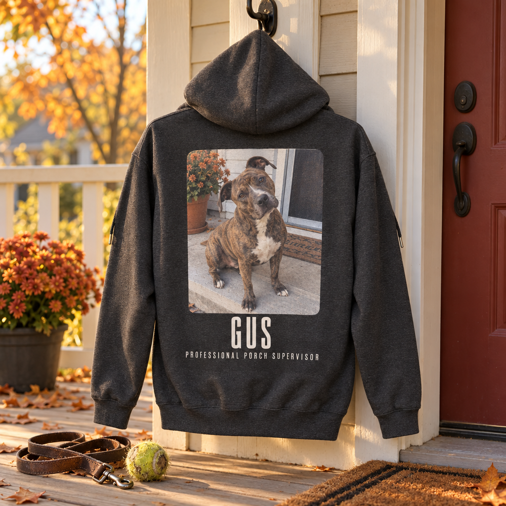 Dark heather custom zip-up hoodie hung on a porch hook, the back printed with a candid porch photo of a brindle dog and the name Gus