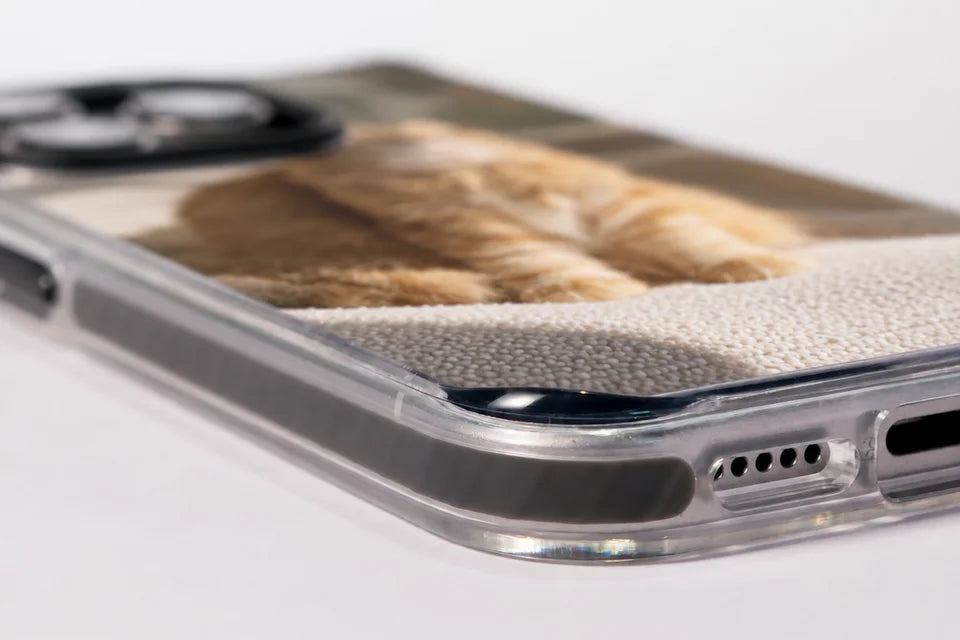 Close-up of the Ultimate + MagSafe case corner: the clear bumper, the speaker holes and the charging port