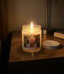 Custom photo candle lit on nightstand with warm glow