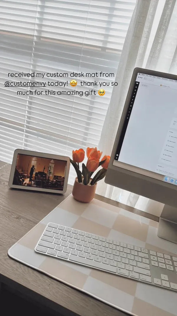 Checkered pattern desk mat with tulips and keyboard by window